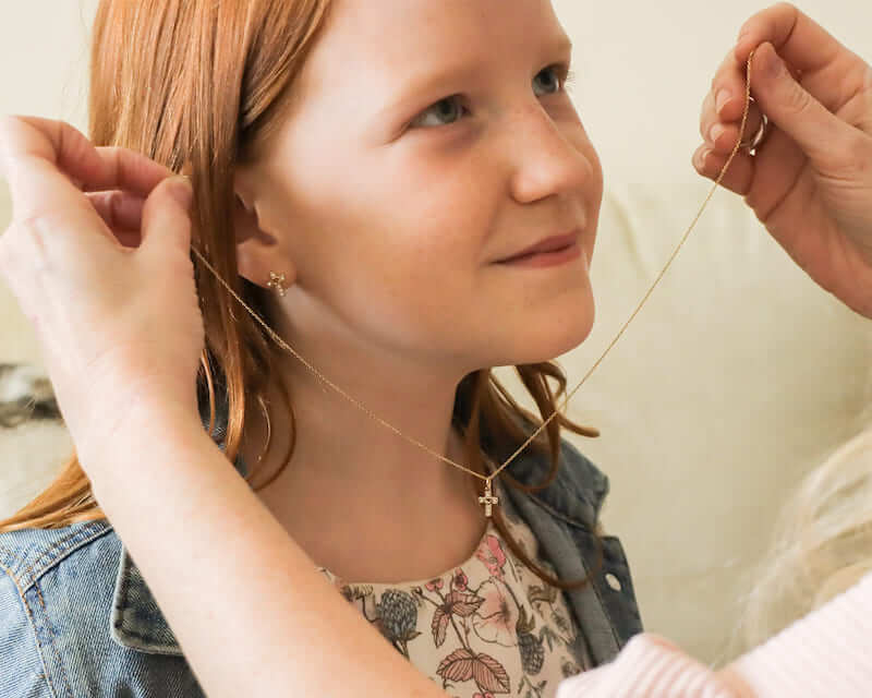 Girl scout receiving a Christian pendant.